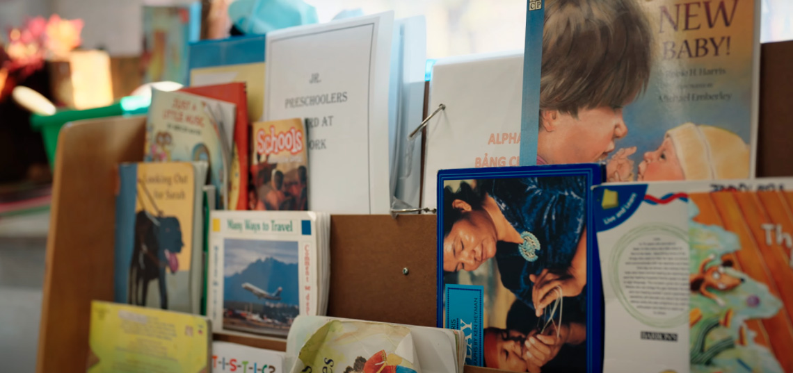 A stack of children's books on a book shelf.